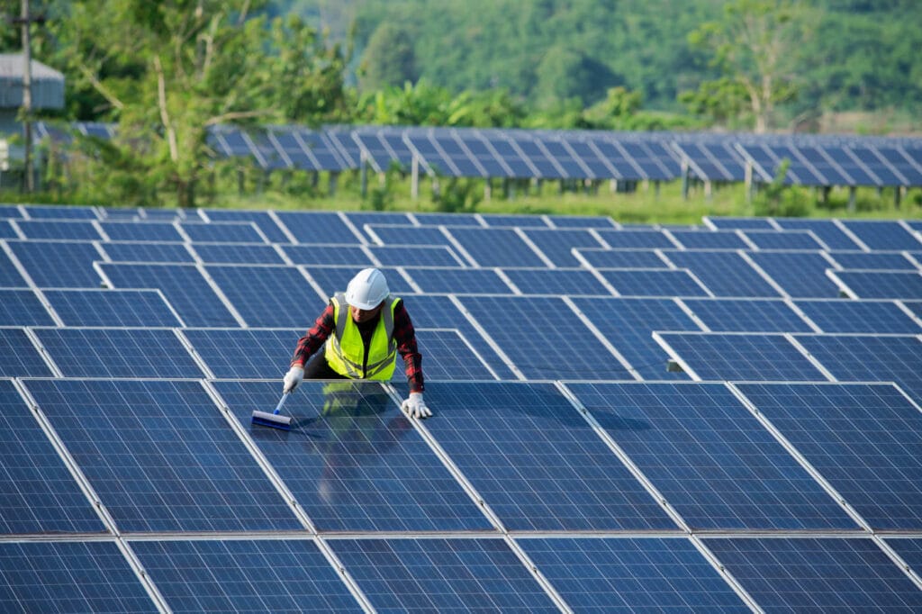 Operaio che pulisce i pannelli di un impianto fotovoltaico