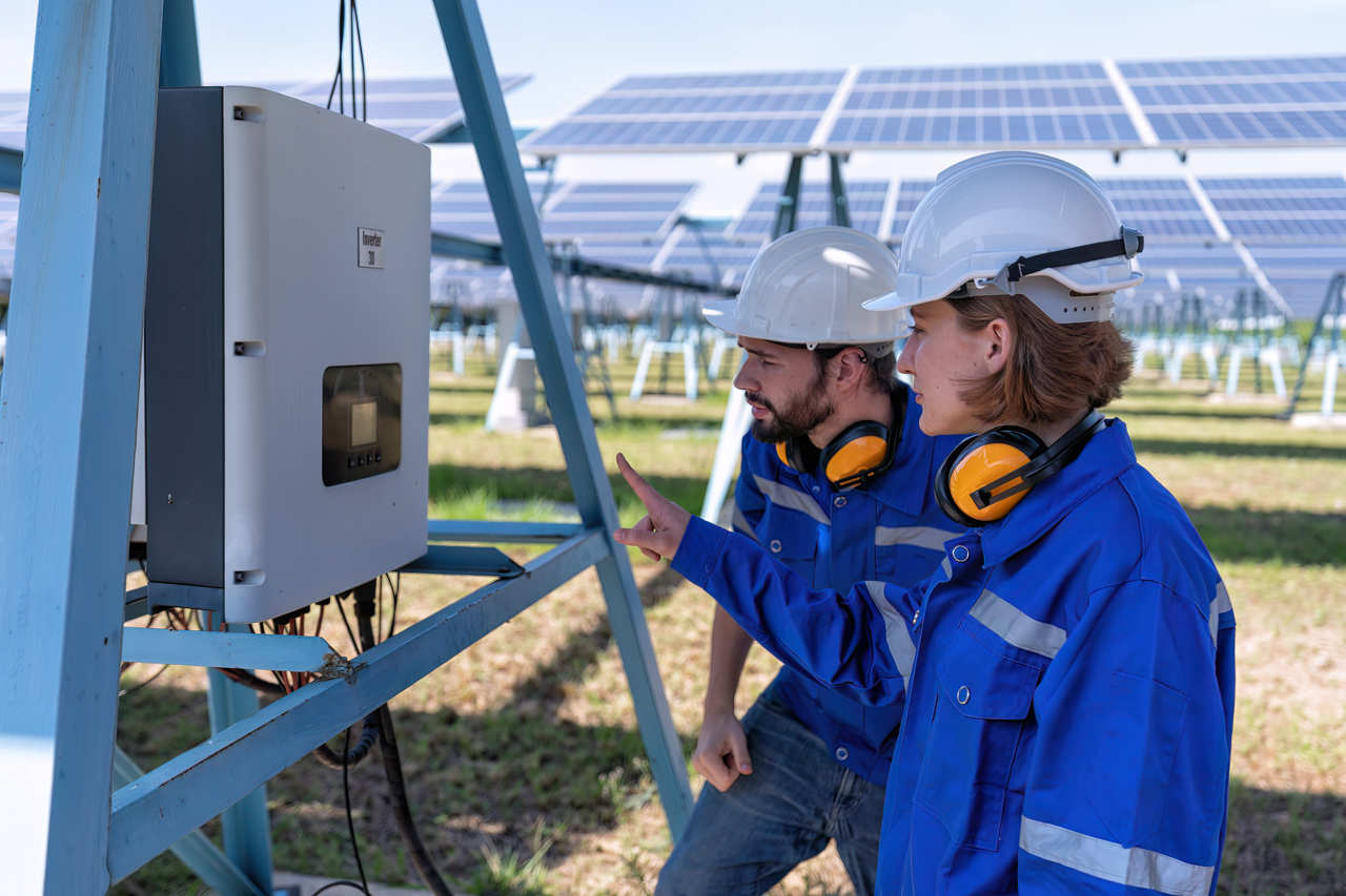 Tecnici che controllano il funzionamento di un inverter di un impianto fotovoltaico