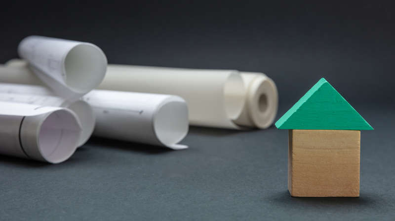 Modellino di una casa e documenti vari come simbolo di vendita di energia prodotta