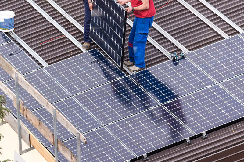 Operai che installano un pannelli solare su un tetto di una casa